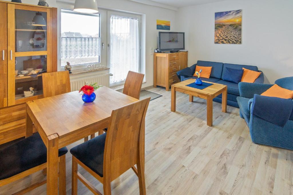 ein Wohnzimmer mit einem Tisch und einem blauen Sofa in der Unterkunft Friesenstübchen in Dornumersiel