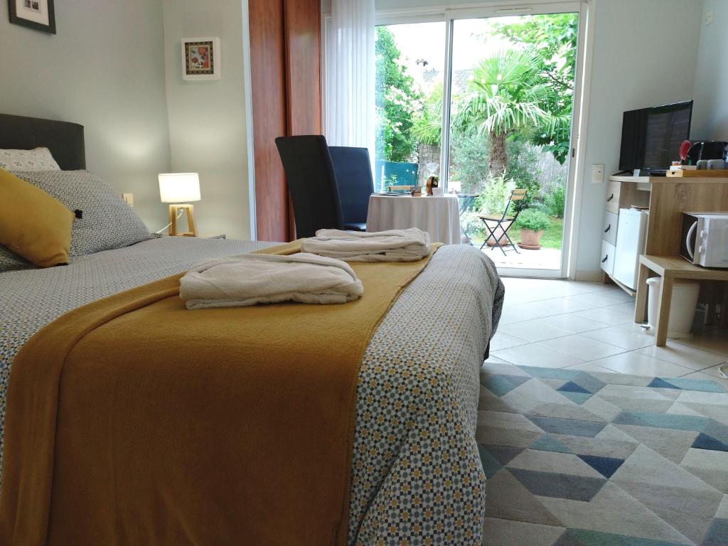 a bedroom with a bed with towels on it at Fleurs de Cosmos in Albi