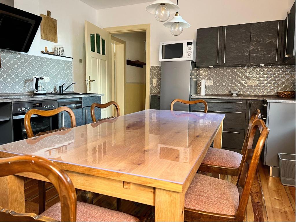a kitchen with a wooden table and chairs at Ferienwohnung Landlust - ideal für Hundefreunde und Monteure, free WLAN & Parken, Smart-TV in Uebigau