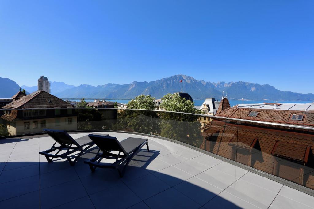 deux chaises assises au-dessus d'un toit avec vue dans l'établissement "The Freddie Mercury" Hotel, à Montreux