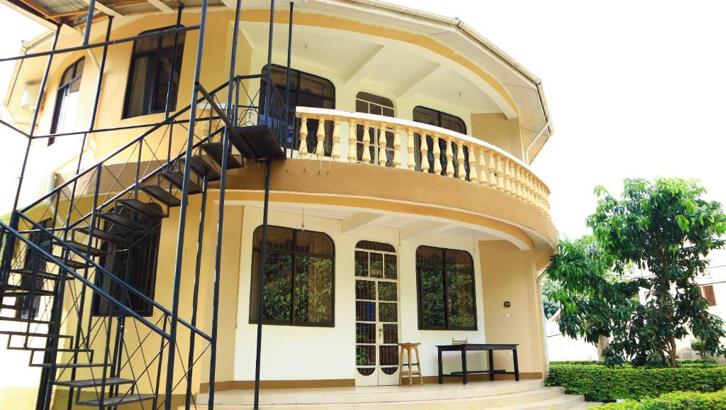 a large yellow building with a spiral staircase on it at Mama Thea homes in Moshi