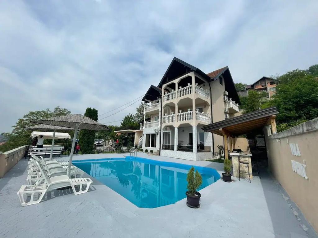 een groot huis met een zwembad en stoelen bij Villa Durmic in Sarajevo