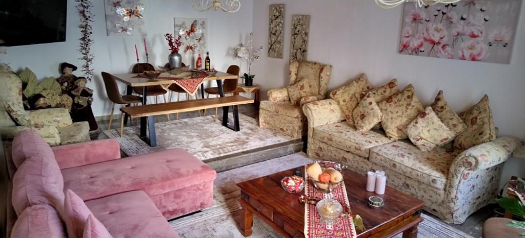 スキアトスタウンにあるKiratsos Houseのリビングルーム(ピンクのソファ、テーブル付)