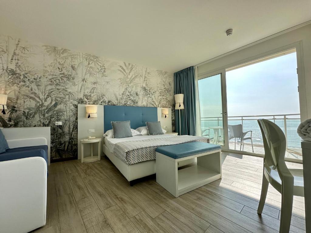 Hotel Nizza Frontemare Superior 3 Stelle في ليدو دي يسولو: غرفه فندقيه بسرير وشرفه