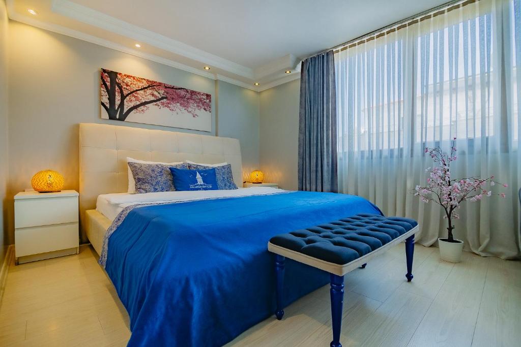 Un dormitorio con una cama azul y una ventana en Galataport Flat Company, en Estambul