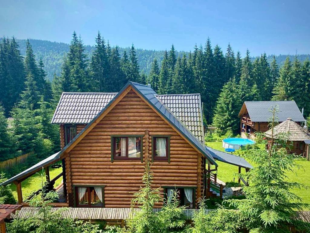 una cabaña de madera en medio de un bosque en Cottage PolyaNitsa окремий котедж з каміном en Bukovel