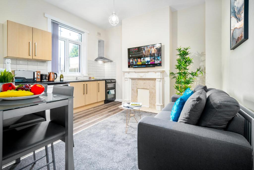 uma cozinha e sala de estar com um sofá e uma mesa em 2 Bedroom Apartment - West Brom - Netflix - Wifi - Parking - Excellent Value - WBA em West Bromwich
