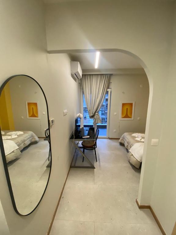 a mirror in a room with two beds and a desk at City Vibe-Sigrou 44 urban studio in Thessaloniki