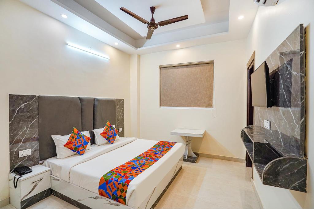 a bedroom with a bed and a desk in it at FabExpress Red Diamond in Ghaziabad