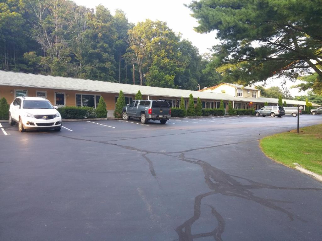 a parking lot with cars parked in front of a building at FairBridge Inn Express in Milford