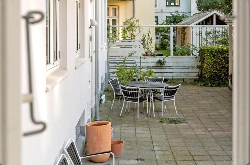 patio ze stołem i krzesłami na boku budynku w obiekcie Frederiksberg w Kopenhadze
