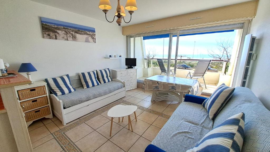 un salon avec un canapé et une table dans l'établissement PLEINE MER - Studio Vue mer à 30m de la plage, à Saint-Jean-de-Monts