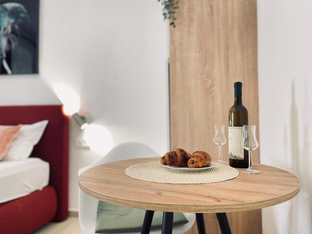 a table with a bottle of wine and a plate of food at Astraluxe in Fažana