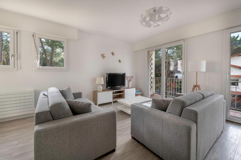 un salon avec deux canapés et une télévision dans l'établissement Détente et évasion à la Baule-Escoublac, à La Baule
