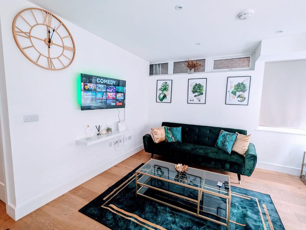 uma sala de estar com um sofá verde e um relógio em x2 suites x2 bedroom with free parking & wifi em Croydon