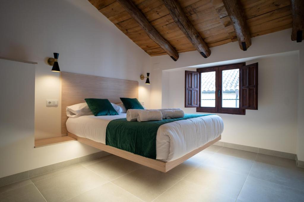 Un dormitorio con una cama grande y una ventana en El Secreto de Chirinos, en Úbeda
