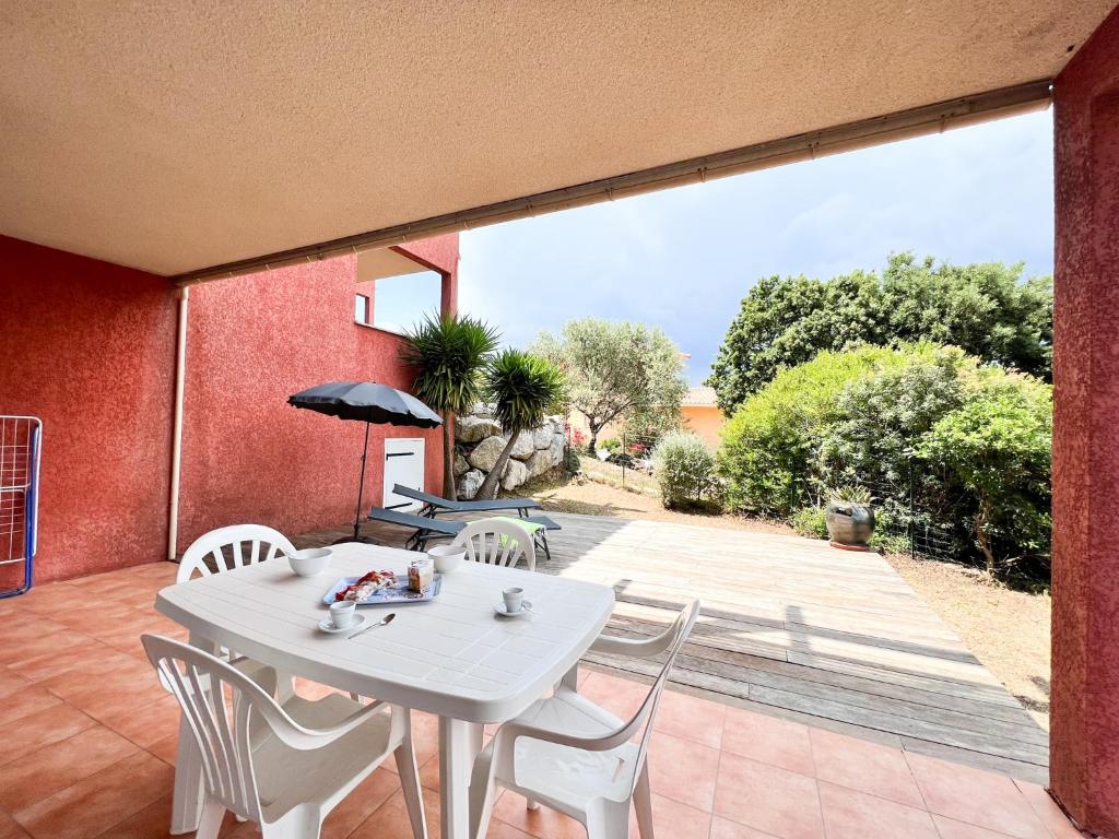 une table blanche et des chaises sur une terrasse dans l'établissement Appartement une chambre dans residence calme, à Propriano