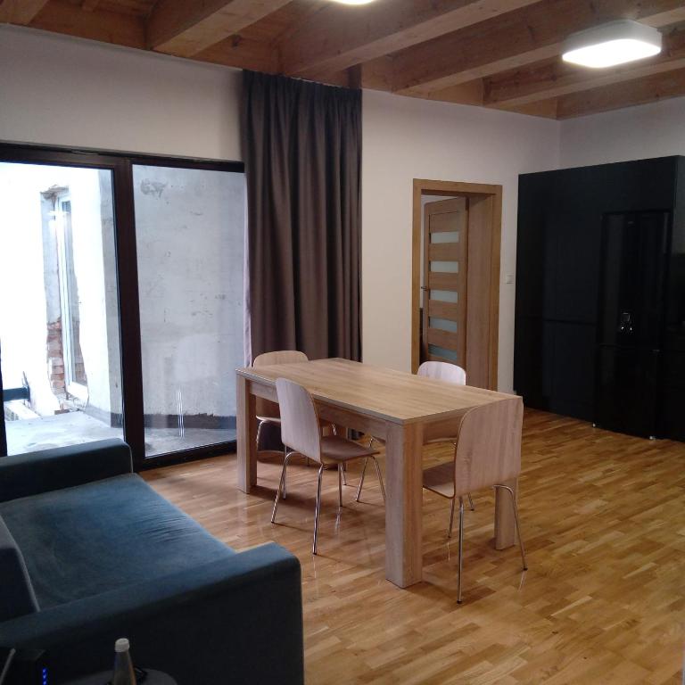 a living room with a wooden table and chairs at Apartament ul. Piłsudskiego 8/5 in Świnoujście