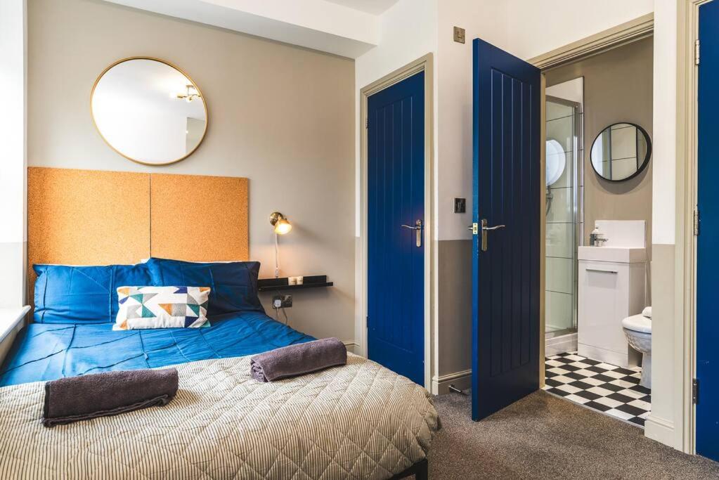 1 dormitorio con cama azul y baño en Stunning Apartment Derby Free Wi-Fi & Parking en Derby
