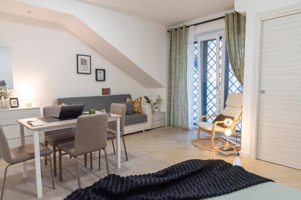 ein Wohnzimmer mit einem Sofa und einem Tisch mit einem Laptop in der Unterkunft KAMCHŪ RESIDENCE - VIA DEI LAGHI: APT #R2 in Ciampino