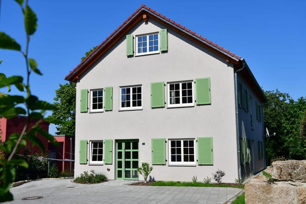 a white house with green shutters at Domizil Eutschützblick in Bannewitz