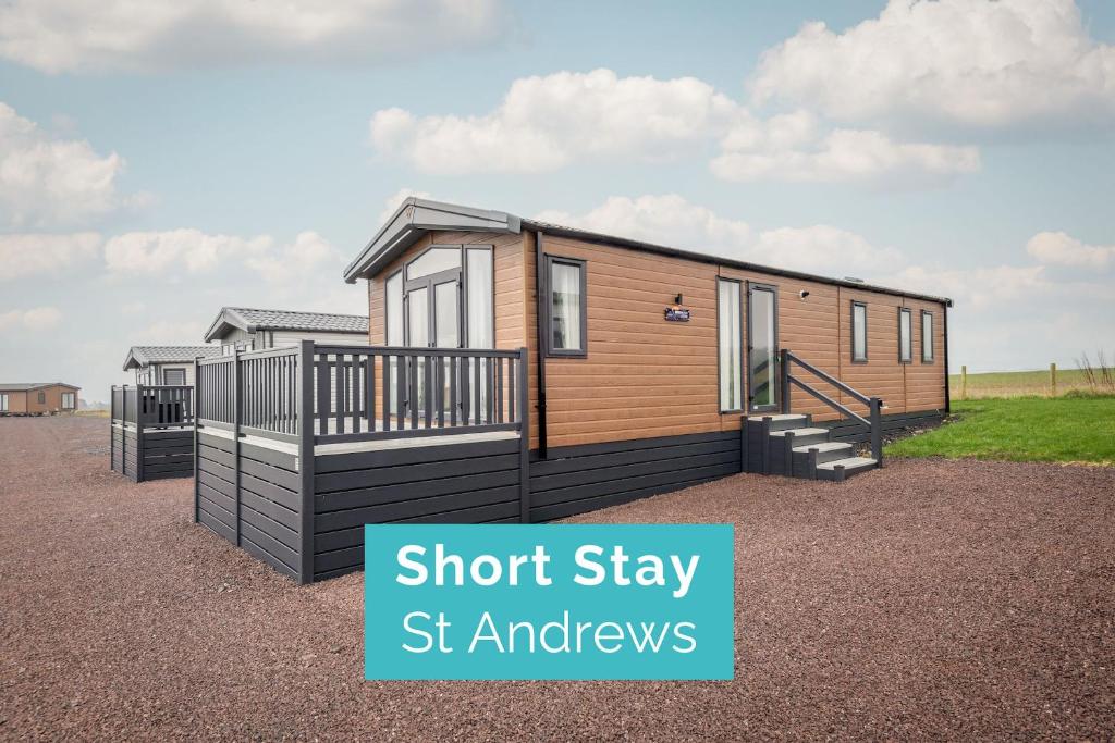 Une petite maison sur un tas de gravier avec les mots "court stay st and ews" dans l'établissement Lodge 14 The Riverwood Close to St Andrews, à Strathkinness