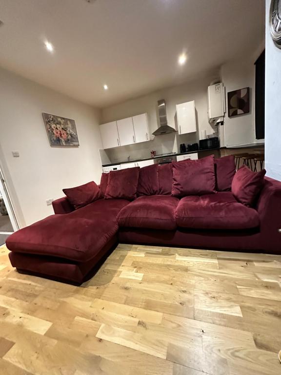 a large red couch in a living room at 2 bed Home away from home tooting London in London