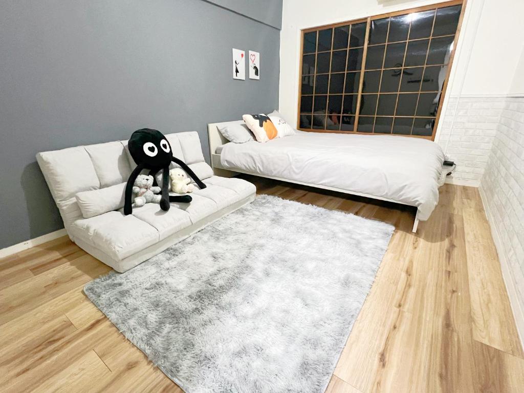 uma sala de estar com um sofá e uma cama em 高田馬場7人可 02 em Tóquio