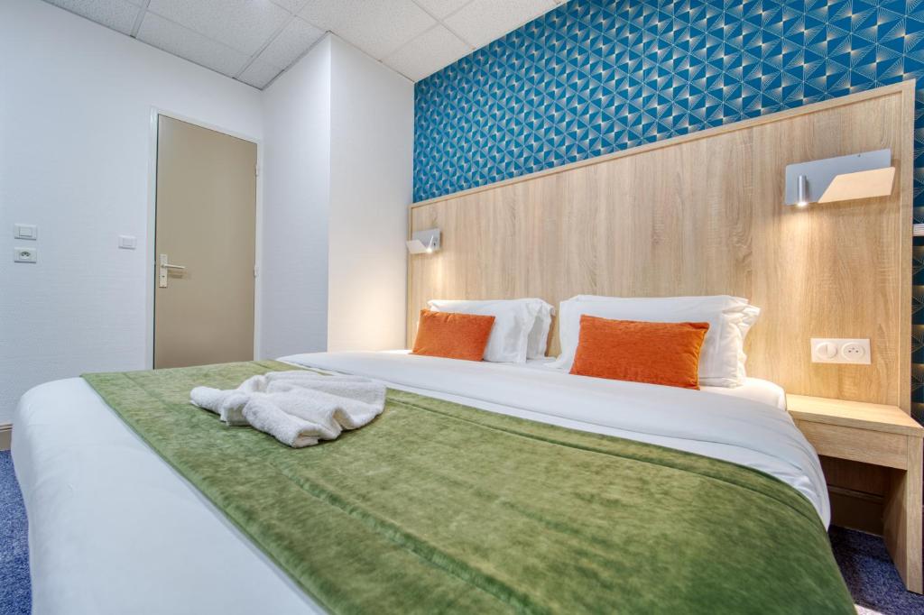 a bedroom with a large bed with towels on it at Hôtel Escurial - Centre Gare in Metz