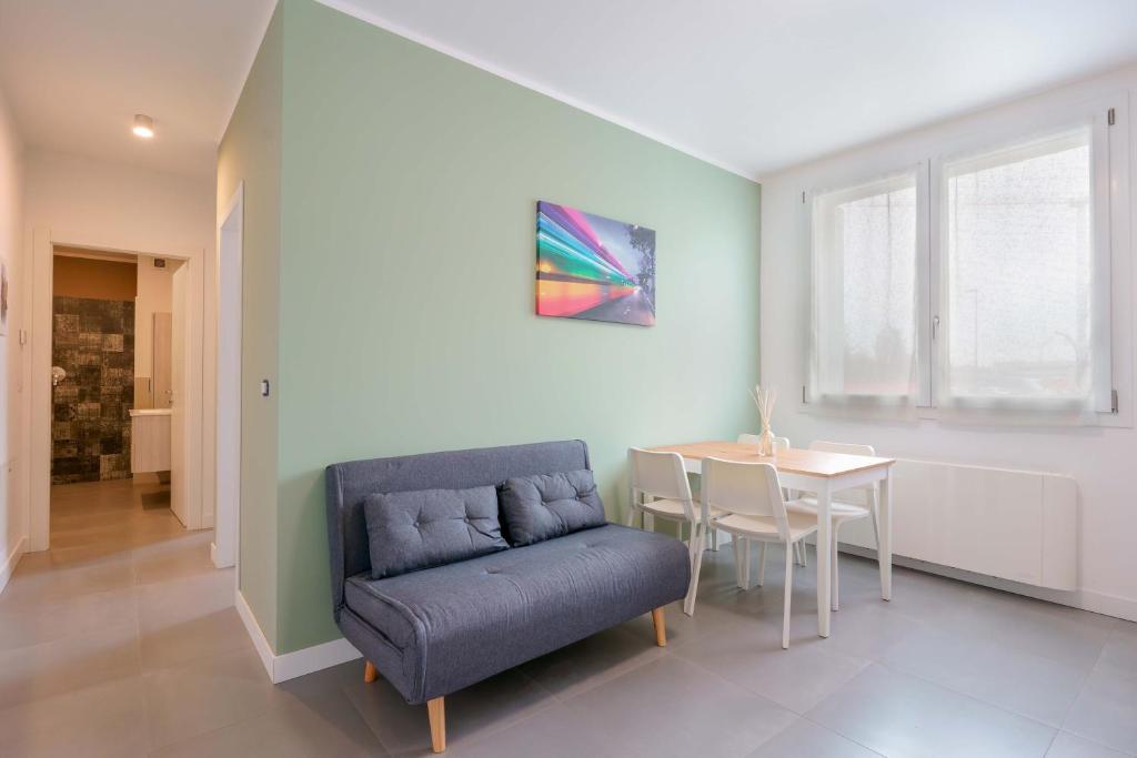 a living room with a blue couch and a table at West Side Bologna Apartment in Bologna