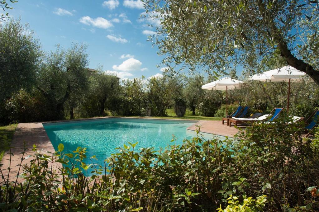 uma piscina com duas cadeiras e um guarda-sol em Lungagnana Apartment Cielo em Nebbiano