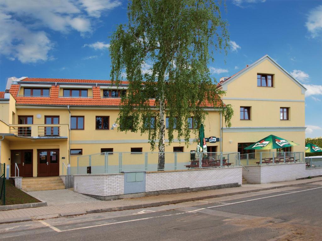 duży żółty budynek po stronie ulicy w obiekcie Penzion a Restaurace Simanda w Pradze
