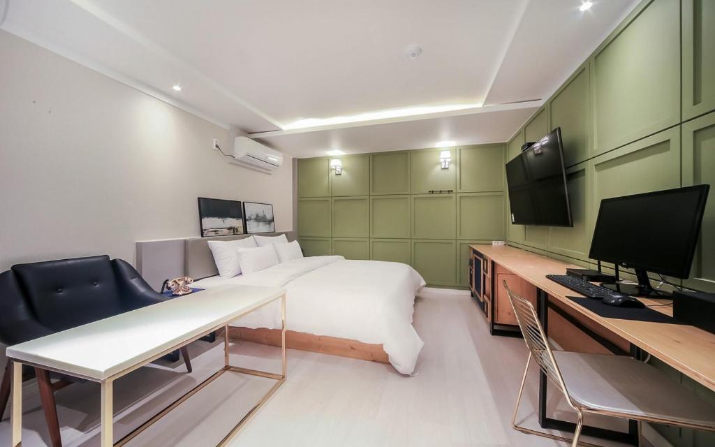 a room with a bed and a desk and a television at Cheese Hotel Seomyeon in Busan