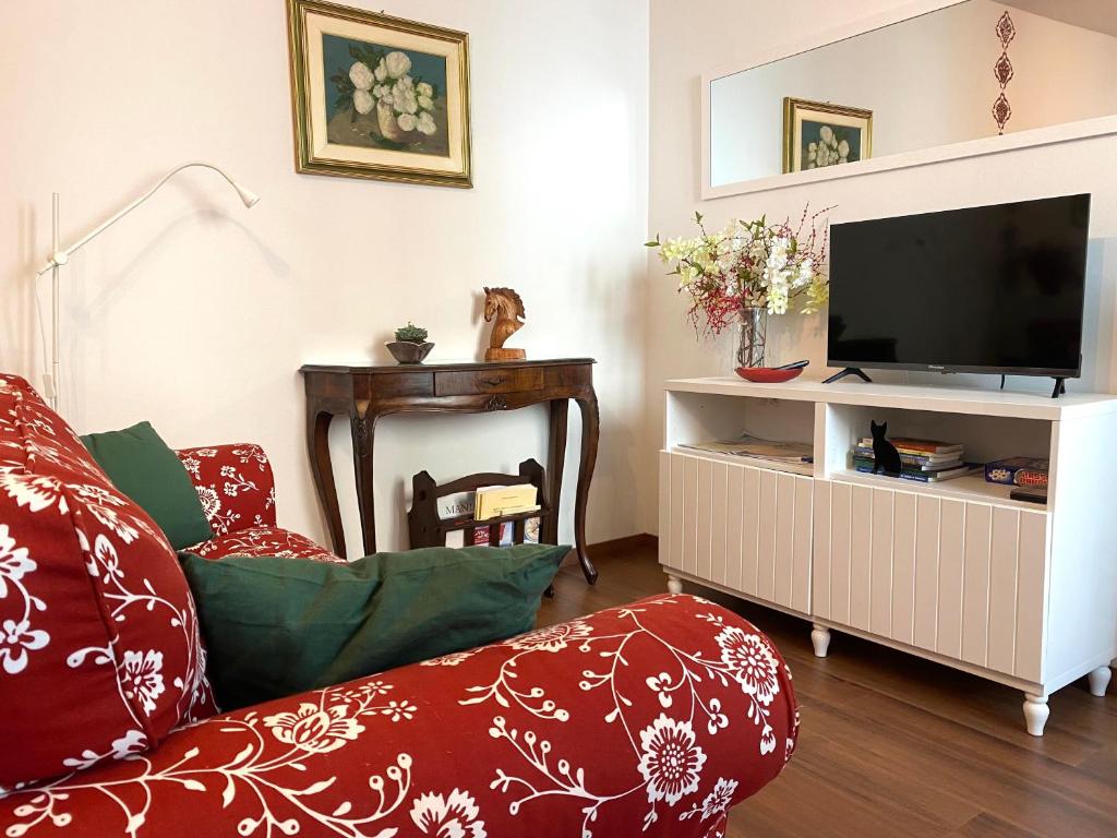ein Wohnzimmer mit einem Sofa und einem TV in der Unterkunft Appartamento Palazzo Montegnacco-Braida in Udine