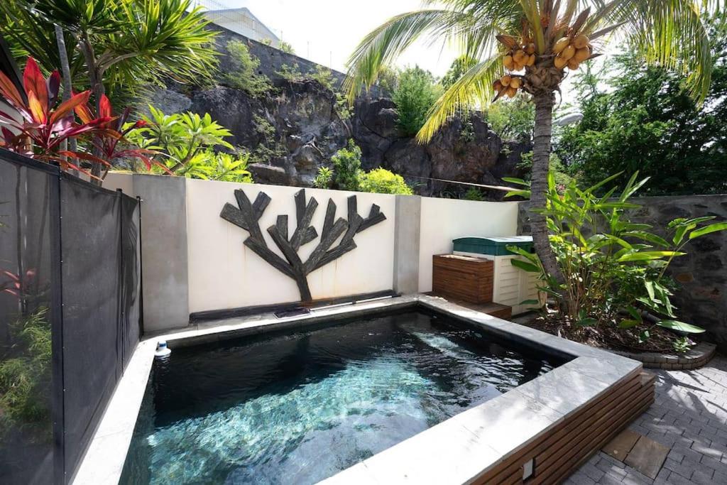 Bazén v ubytování COTTAGE BAMBOU classé 3 étoiles - 4 à 6 personnes - 2 chambres - avec piscine privée et accès direct à la plage et à l'esplanade de Boucan Canot avec ses bars et restaurants nebo v jeho okolí