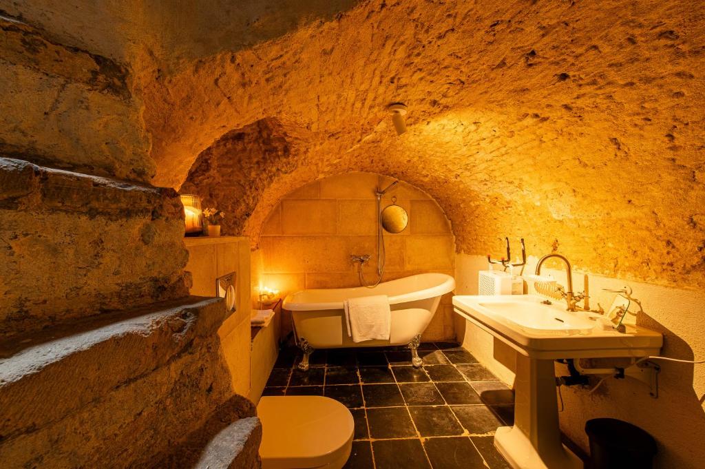 a bathroom with a tub and a sink in a cave at Little Antwerp holiday home in Antwerp