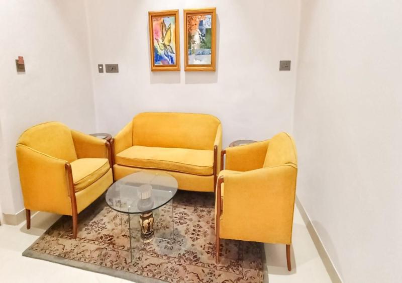 two yellow chairs and a table in a room at Cordial Hotels And Resorts Private Limited in Sītāpur