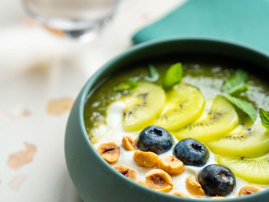 a green bowl of soup with fruit and nuts at Novotel Istanbul Bosphorus Hotel in Istanbul