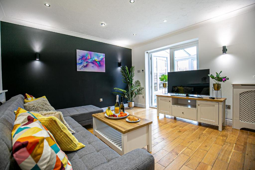 sala de estar con sofá y TV de pantalla plana en Milton Keynes for Families and Contractors with Private Parking, en Shenley Brook End