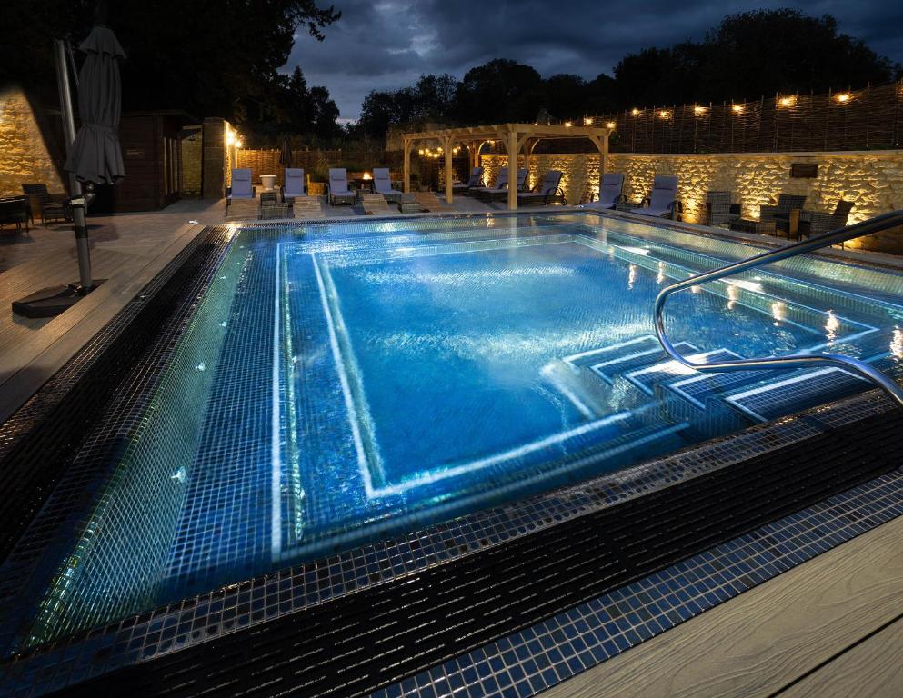 a large swimming pool with blue water at night at Barton Hall Hotel & Spa in Kettering