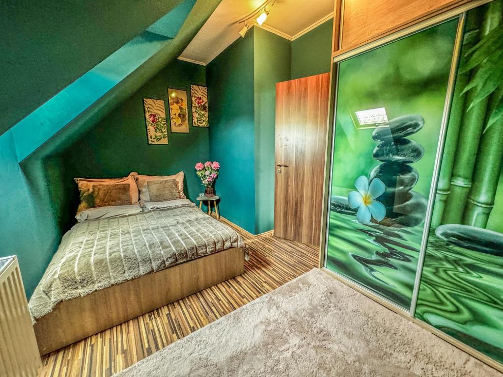 1 dormitorio con cama y pared verde en Spa Residence Családi Wellness Apartman, en Veszprémfajsz