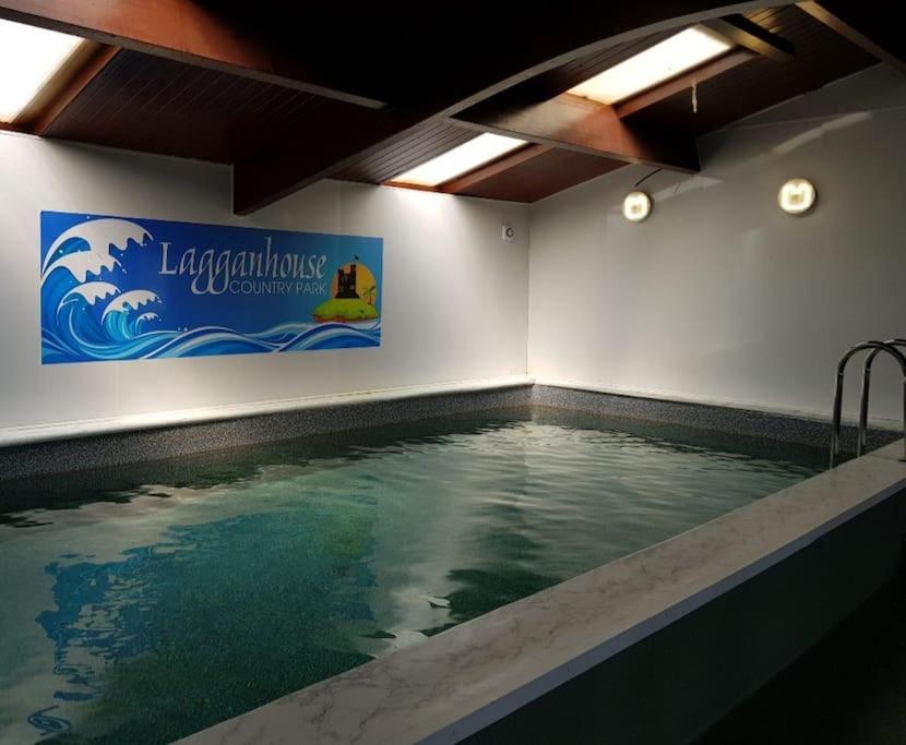 a large swimming pool with a sign on the wall at Hill View in Ballantrae