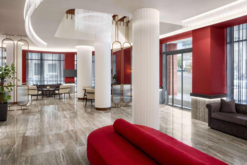- un salon avec des murs rouges et un canapé rouge dans l'établissement Athens Key Hotel, Trademark Collection by Wyndham, à Athènes