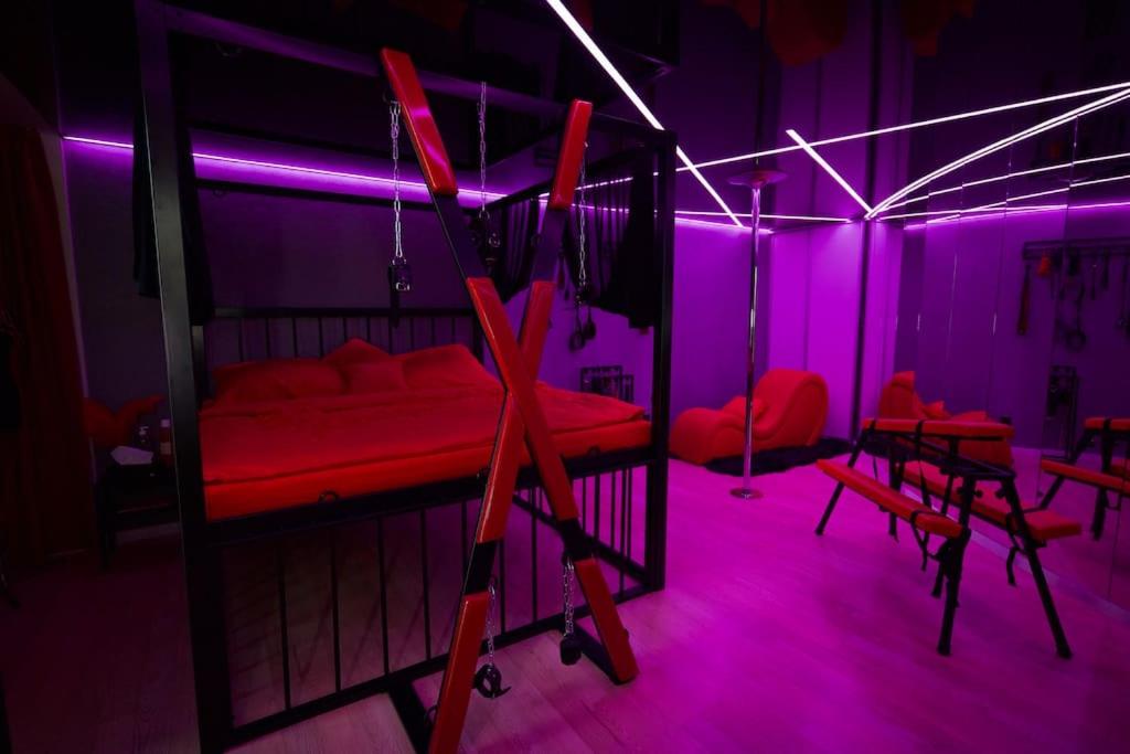 Pokój z łóżkiem z czerwonym i fioletowym światłem w obiekcie BDSM apartmán v Bratislave -ADULTS ONLY w Bratysławie