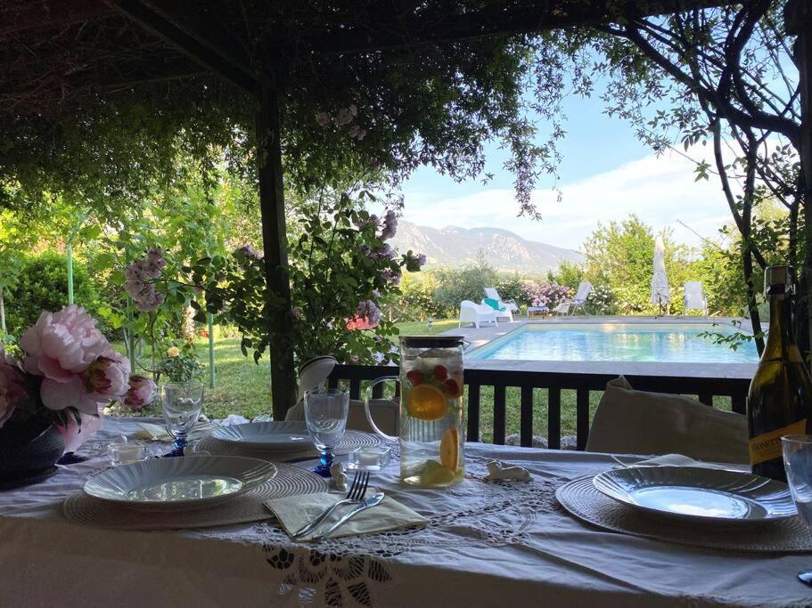 einen Tisch mit Tellern und Weingläsern sowie einen Pool in der Unterkunft villa le Querce with private swimming pool in San Gemini