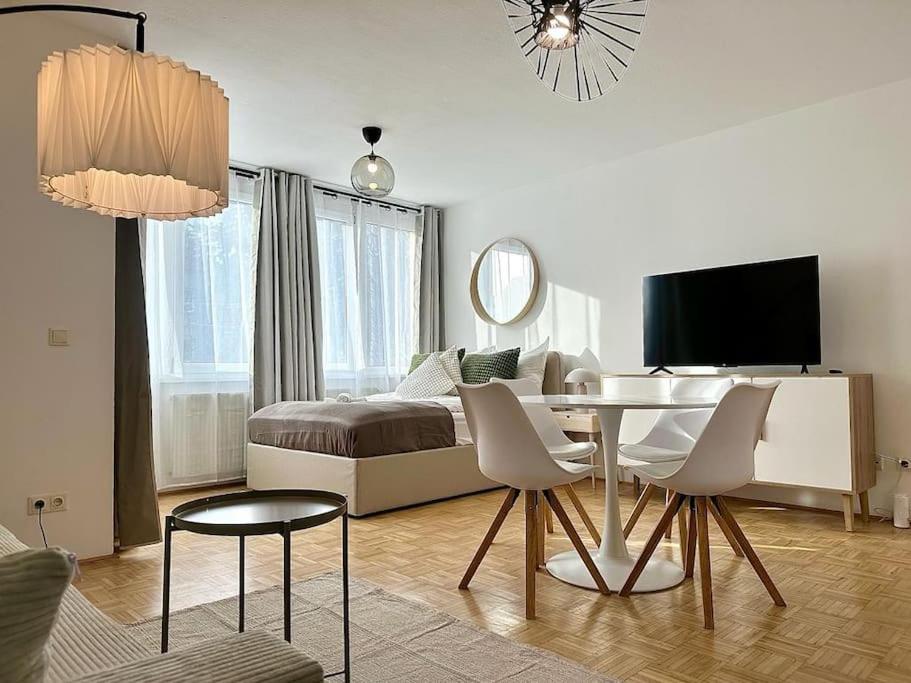 ein weißes Zimmer mit einem Bett, einem Tisch und Stühlen in der Unterkunft Chic Apartment - Quiet Area - Next to Hospital in Wien