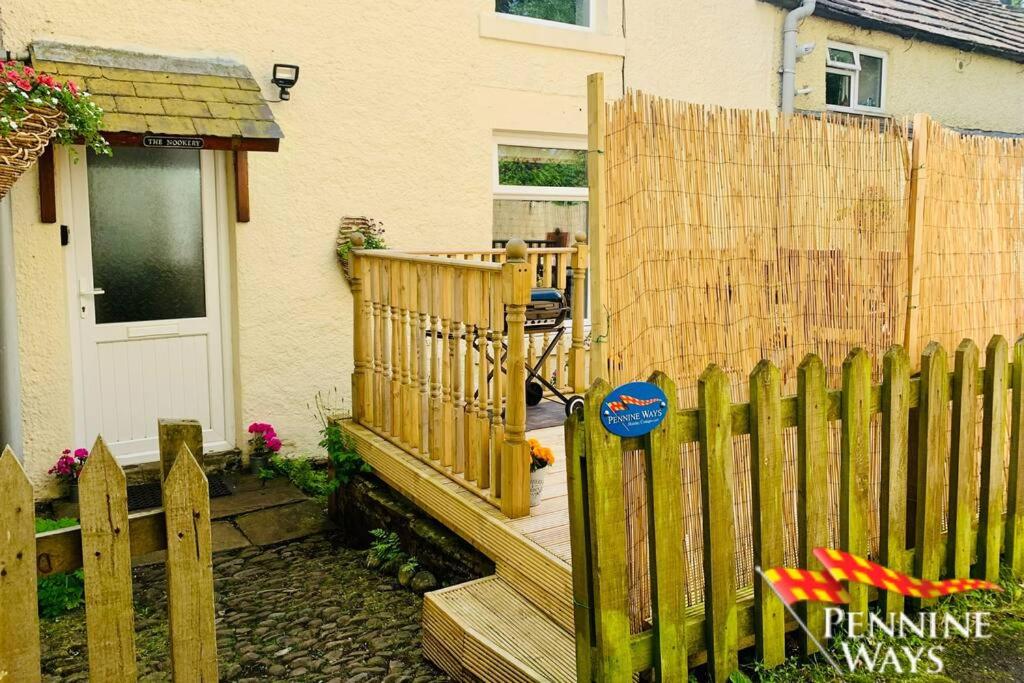 a wooden fence in front of a house at The Nookery - Cosy Cottage in the Heart of Town in Alston