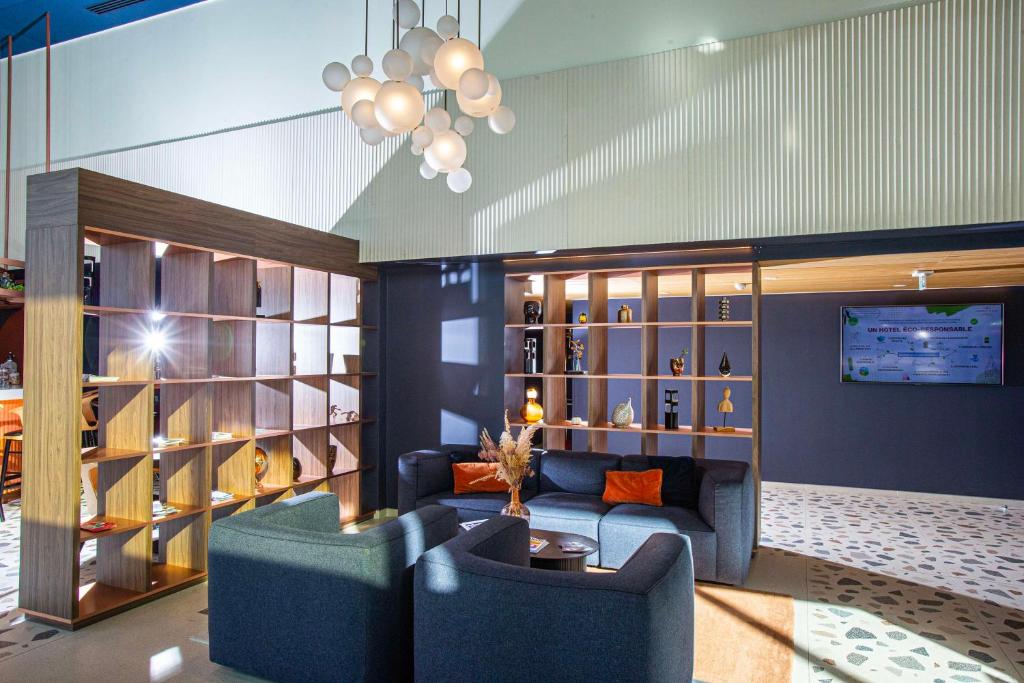 a living room with a blue couch and a table at Hotel Lille Euralille - Hilton Affiliate Hotel in Lille