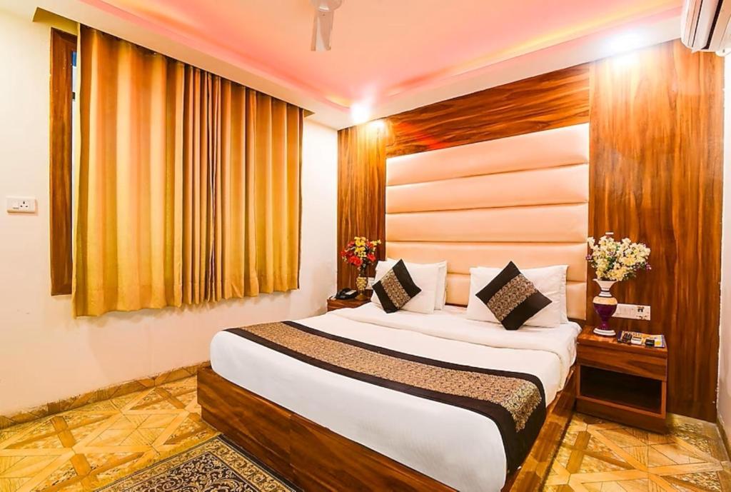 a bedroom with a large bed in a room at Aerocity Hotel Zindal Plaza at Delhi Airport in New Delhi