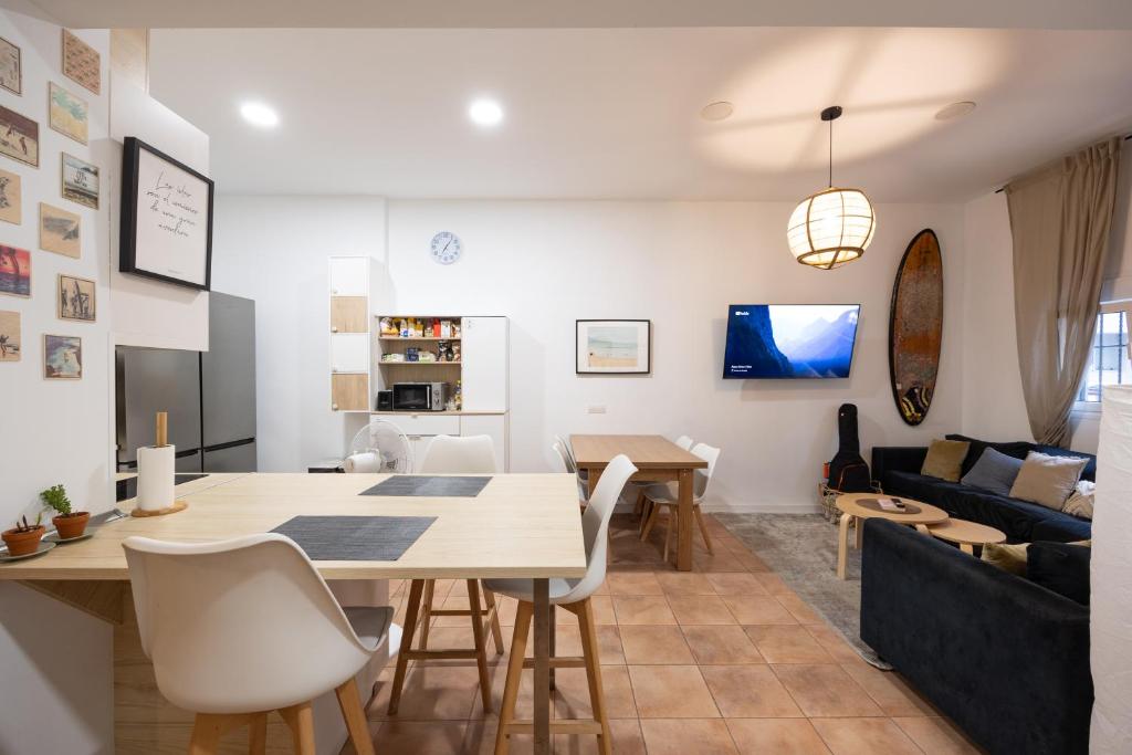 a dining room and living room with a table and chairs at Kite & Surf Nomad House in Las Palmas de Gran Canaria
